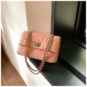 Détail du sac bandoulière rose avec matelassage courbé et fermoir rotatif argenté