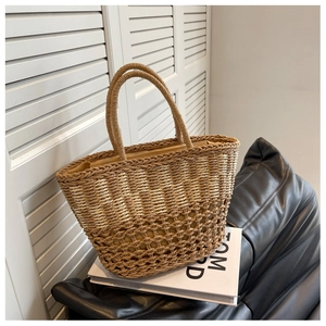 Detailed close-up of woven straw tote bag with intricate hollow mesh and fabric lining
