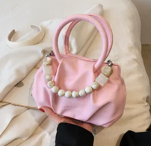 Detailaufnahme der rosa Plisseetasche mit stilvollen Marmormuster-Zierperlen