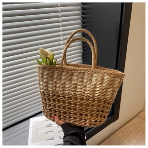 Close-up of a woven straw tote bag with intricate mesh patterns and round handles