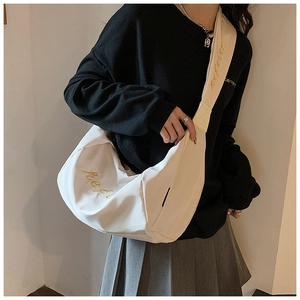 Detail of white nylon crescent bag showing elegant gold embroidery and a wide strap