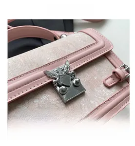 Macro shot of silver pegasus buckle and textured pink leather on a stylish handbag