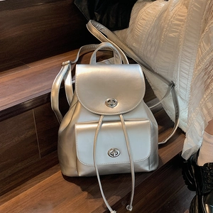 Sac à dos argenté métallisé chic avec boucles et cordon de serrage sur escaliers