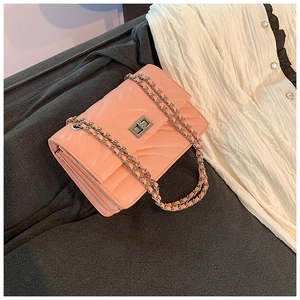 Gros plan du petit sac bandoulière rose matelassé en V avec fermoir rotatif argenté