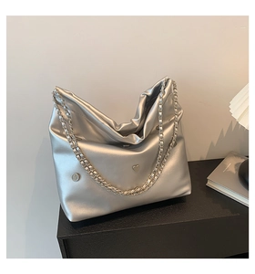Detail of silver chain shoulder bag with heart buckle and metallic hobo design