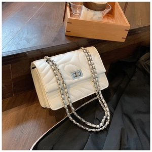 Détail du sac blanc matelassé à motif ondulé avec fermoir rotatif en métal argenté