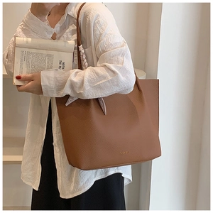 Detailed view of large brown lychee grain tote bag with decorative floral scarf on handle