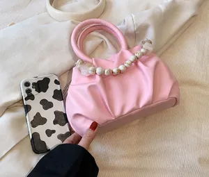 Detailansicht der rosa Rafftasche mit Marmorperlen-Griff und Smartphone-Vergleich