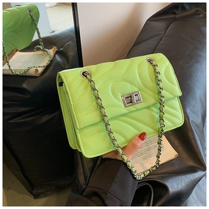 Détail du sac bandoulière vert fluo à matelassage ondulé et fermoir rotatif argenté
