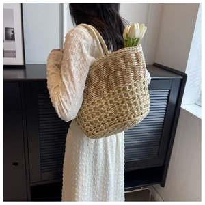 Close-up of bohemian woven straw beach tote featuring a dual-tone hollow mesh design