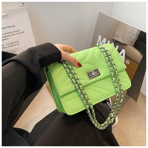 Détail du sac matelassé vert néon avec chaîne, fermoir argenté et coutures ondulées
