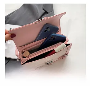 Interior detail of a pink crossbody bag showing three compartments for phones and makeup
