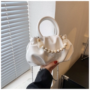 Detail of white pleated cloud bag with marble beads and silver chain strap