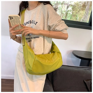 Close-up of bright yellow-green nylon hobo bag with efeier artistic embroidery detail