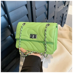 Détail du sac bandoulière matelassé vert fluo avec fermoir rotatif argenté et chaîne