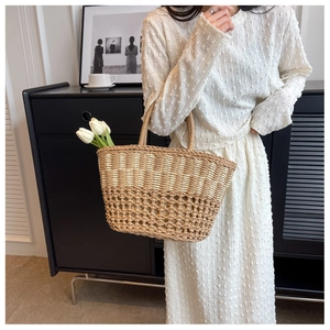 Close-up of dual-tone straw tote bag with intricate diamond hollow weave and round handles