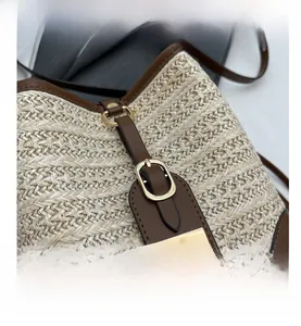 Close-up of beige straw texture with brown leather trim and golden metal buckle