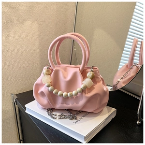 Detailed macro of pink pleated cloud bag with marble bead chain and leather handle