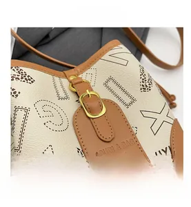 Détail du sac à bandoulière en cuir blanc cassé avec boucle dorée et motifs imprimés