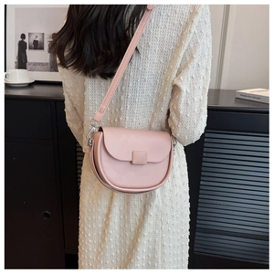 Detail of a light pink saddle bag with square buckle paired with white jacquard dress