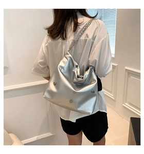 Detail of silver metallic hobo bag with large chain strap and metal buckles