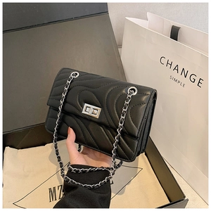 Détails du sac bandoulière en cuir noir matelassé avec fermoir argenté et chaîne