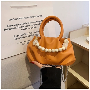 Detail einer orangefarbenen Plissee-Handtasche mit Silberkette und Marmordekorperlen