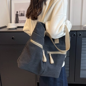 Large dark grey canvas tote bag with multi-pocket design and beige shoulder straps