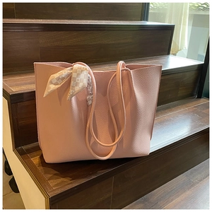 Close-up of pink litchi grain leather tote bag with elegant floral scarf detail
