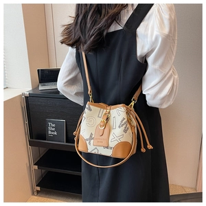 Détail du sac seau à cordon avec imprimé lettres et bandoulière en cuir marron