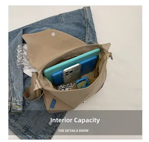 Vue intérieure du sac bandoulière en toile kaki montrant l'espace pour tablette et mobile