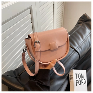 Detail view of pink saddle bag with adjustable strap and faux leather texture