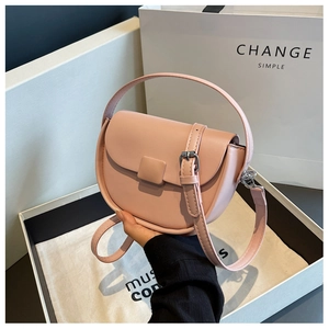 Detail of pink leather saddle bag with square buckle and silver hardware on white gift box