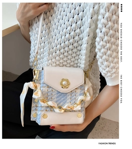 Detail of tweed crossbody bag with pearl floral buckle and polka dot scarf chain strap