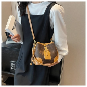 Détail d'un sac seau vintage avec motifs monogrammes et garniture en cuir sur mannequin