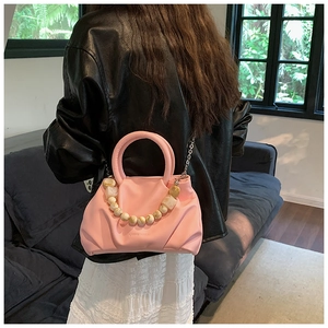 Pink pleated cloud bag detail featuring marble resin beads and metallic chain strap