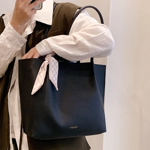 Large black leather tote bag with silk scarf accessory and gold fashion lettering