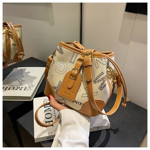 Détail d'un sac seau à cordon avec lettres léopard et finitions en cuir marron