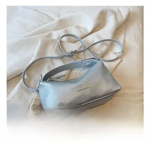 Vue détaillée du cuir argenté texturé et de la bandoulière réglable sur le sac à main