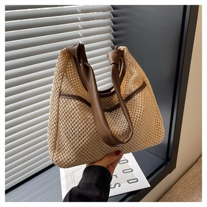 Detailed close-up of woven straw texture with brown faux leather knotted handles