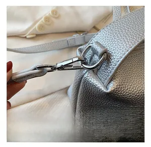 Détail du crochet pivotant en argent brillant et texture du cuir sur le sac à main