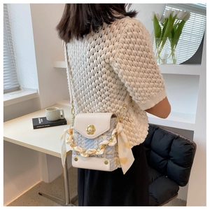 Detail of tweed crossbody bag with pearl flower clasp and silk scarf wrapped chain
