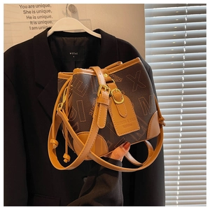 Détail du sac seau monogramme avec fermeture à cordon et étiquette en cuir