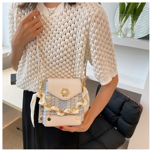 Detail of tweed crossbody bag with pearl logo, silk scarf handle and golden chain strap