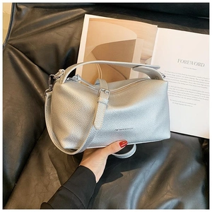 Détail du sac en cuir argenté à texture grainée avec bandoulière et fermetures métalliques