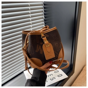 Détail du sac seau avec imprimé monogramme marron et bandoulière en cuir réglable