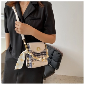 Detail of tweed crossbody bag with pearl buckle and heart print silk scarf accessory
