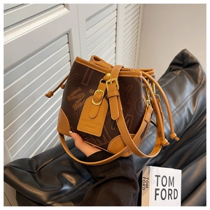 Gros plan d'un sac seau marron avec motif monogramme et fermeture par cordon