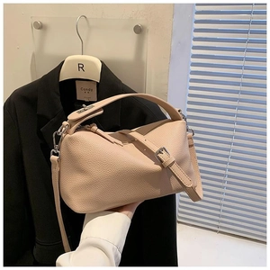 Détail d'un sac à main en cuir grainé rose clair avec ferrures et bandoulière chic