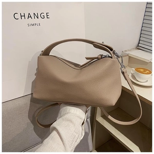 Détail du sac à main beige en cuir grainé avec poignée simple et bandoulière réglable